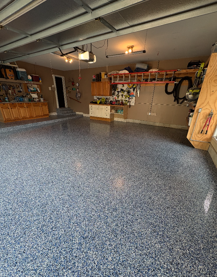 Finished flake epoxy garage floor with organized storage, an HKH Custom Coatings project
