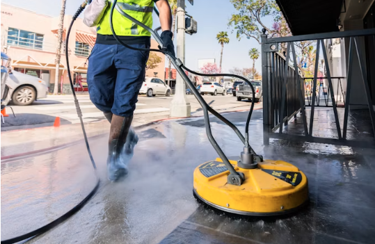 Power washing a commercial sidewalk and storefront